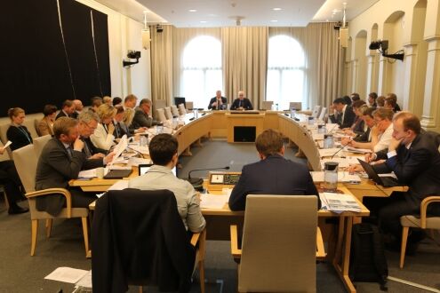 Personer som sitter rundt et bord i et møte