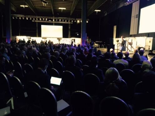 Personer som sitter i en konferansesal.